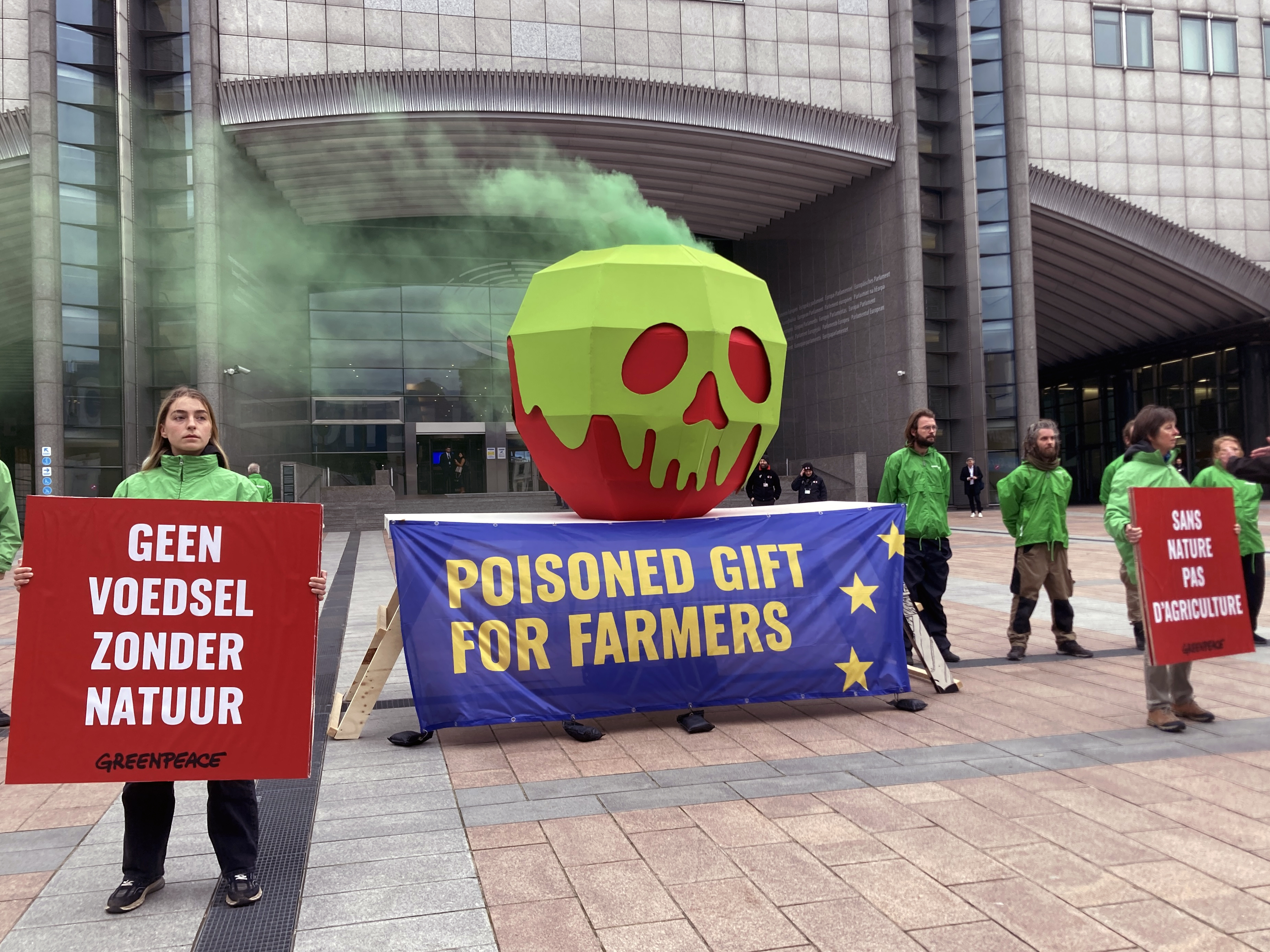 greenpeace dépose une pomme géante empoisonnée devant le parlement européen