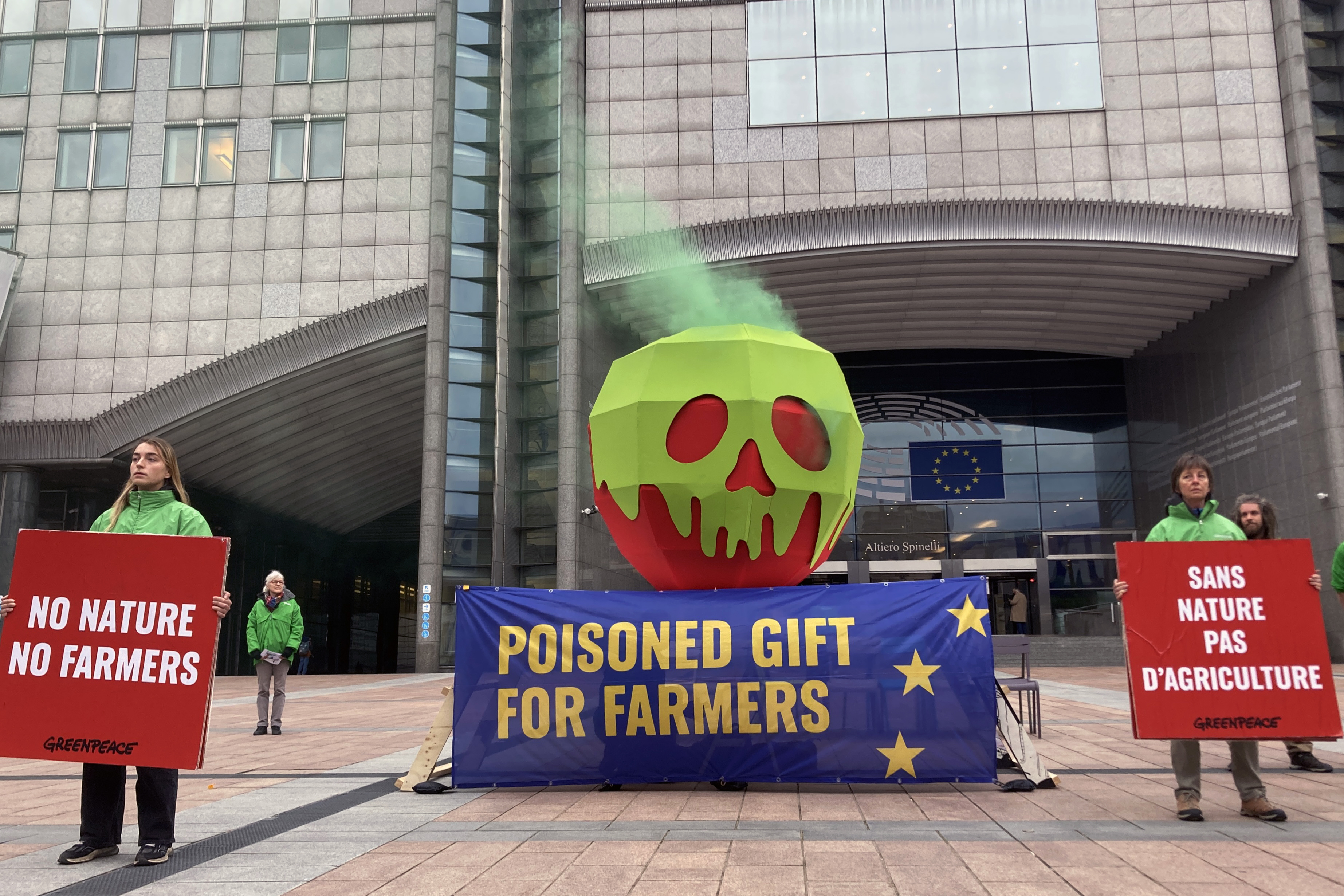 greenpeace dépose une pomme géante empoisonnée devant le parlement européen