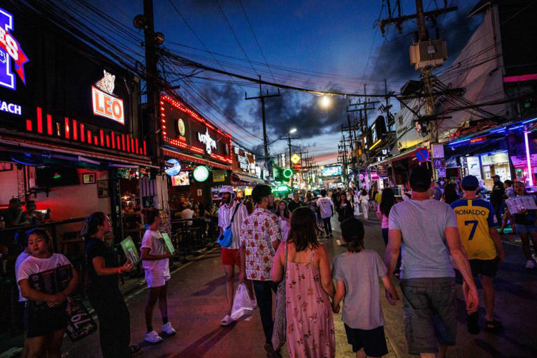 People walk down Bangla Road after sunset in Phuket, Thailand, on July 6, 2023.