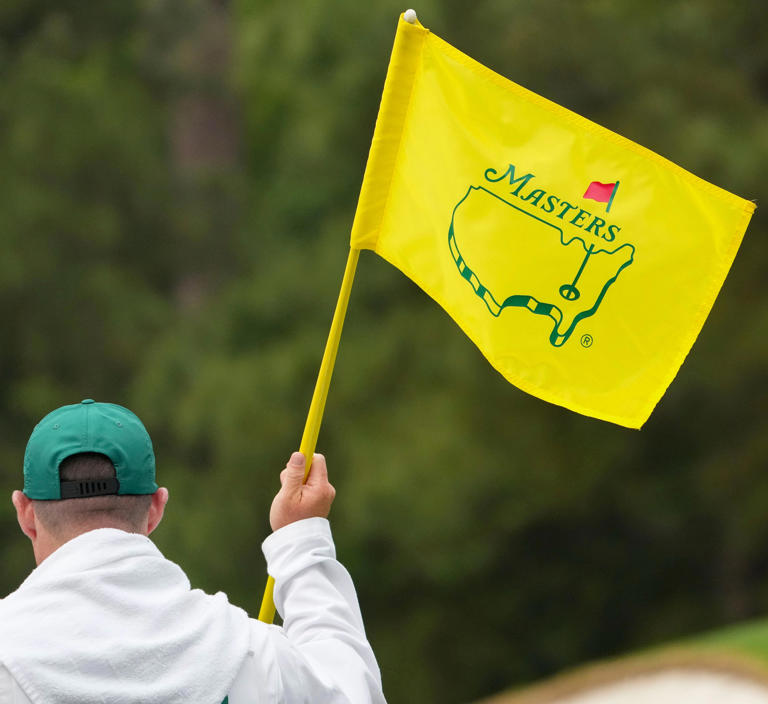 A Masters flag is held on the third green during a practice round for the Masters golf tournament at Augusta National Golf Club.