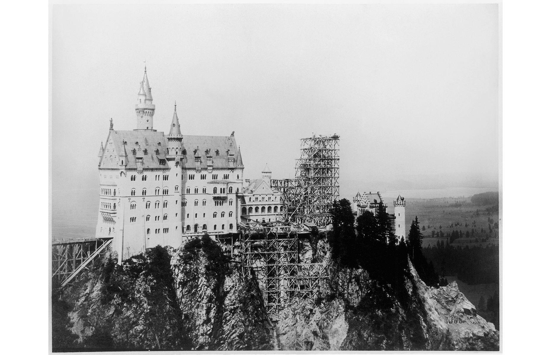 <p>This fairy-tale castle famously influenced the design of castles in early Disney movies – and by extension the modern Disney logo. But its real-life history is much less magical. It was built on the orders of King Ludwig II of Bavaria – a dreamer sometimes known as 'the mad king' – with a deliberately medieval aesthetic atop a vertiginous rocky ridge. Construction started in 1869 and Ludwig hoped, extremely optimistically, to move in within three years. He died in 1886 – the year this photo was taken – with much of the building still obscured by scaffolding.</p>  <p><strong>Liking this? Click on the Follow button above for more great stories from loveEXPLORING</strong></p>