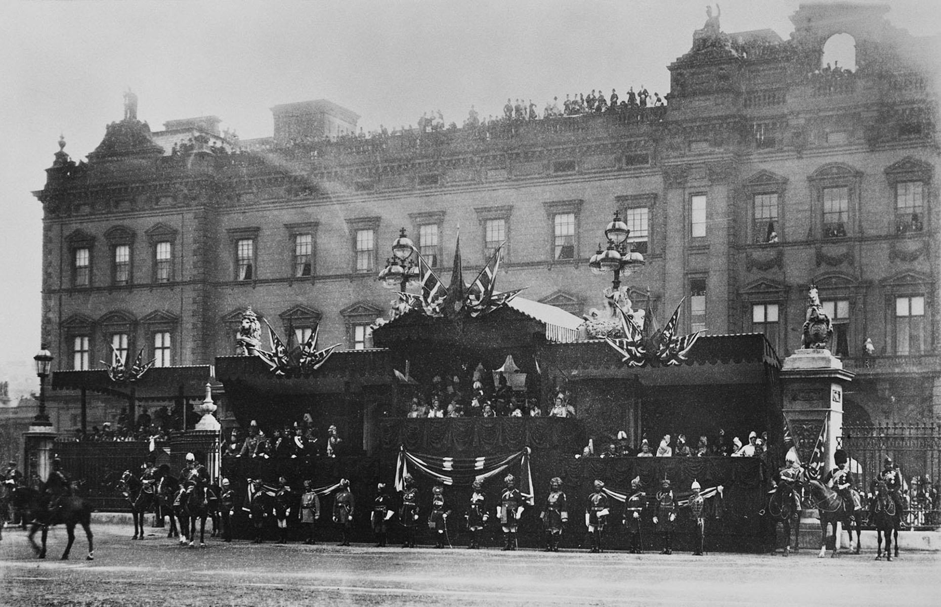 <p>No visit to London is complete without seeing Buckingham Palace. It has been the London residence of British monarchs since 1837 and the guards that protect it, wearing red uniforms and tall bearskin hats, are famous around the world. This photo shows Queen Victoria reviewing a parade during her Diamond Jubilee in 1897. The edifice appears darker than it is today; it was refaced in Portland stone in 1913 by Aston Webb to provide a fitting backdrop for the grand monument to Queen Victoria.</p>