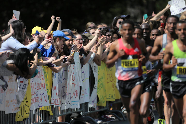 The men’s elite field passes Wellesley College during the Boston Marathon. (Lane Turner/Globe Staff)