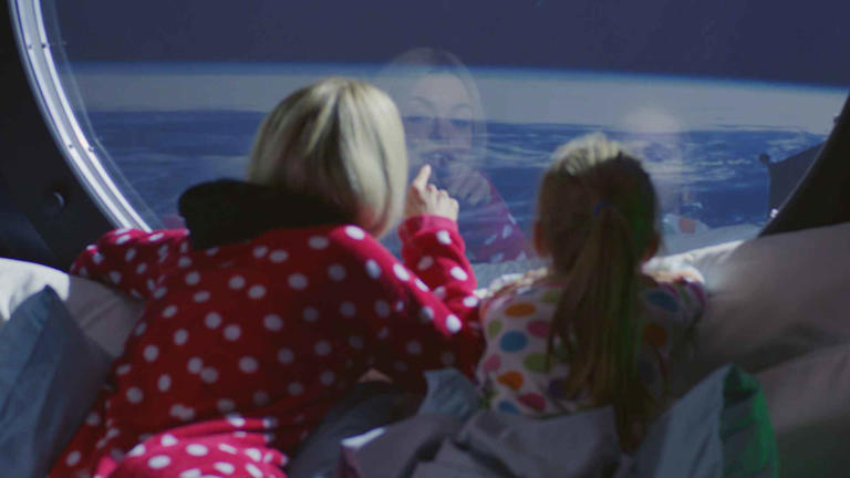 Mother and daughter enjoying view from spaceship