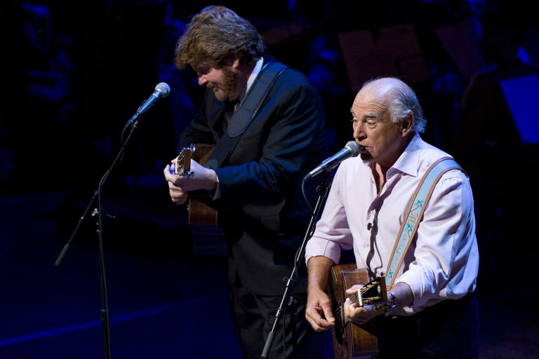 Singer-songwriter Jimmy Buffett (R) plays "Son of a Sailor" during a memorial service for CBS newsman Walter Cronkite at the Lincoln Center in New York City, NY, Sept. 9, 2009. Walter Cronkite died on July 17, 2009, at age 92.