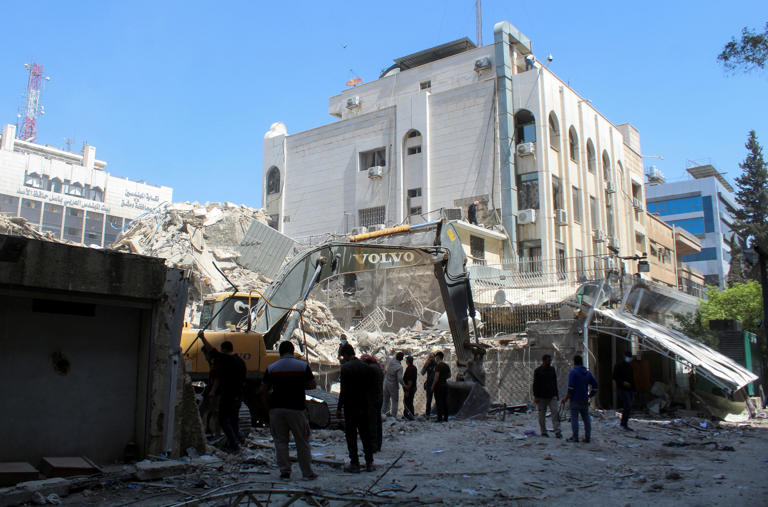 An excavator clears rubble after an attack on April 1, 2024, on Iran's consulate in the Syrian capital, Damascus [File: Firas Makdesi/Reuters]