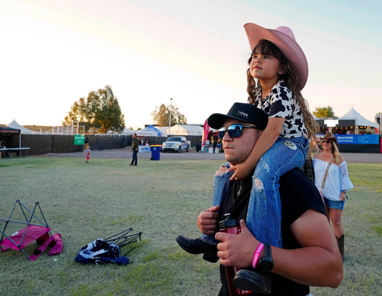 Heartlee Shelby listens to country music on the shoulders of her dad, Anthony, during Country Thunder in Florence on April 12, 2024.