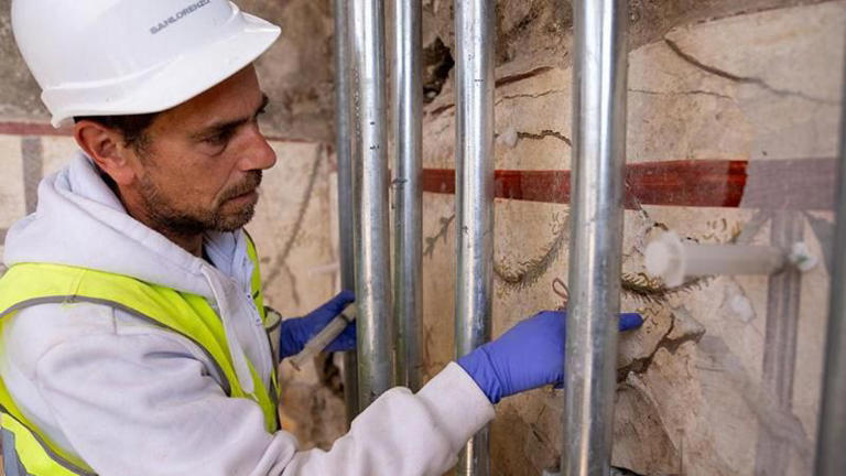 Hace falta inyectar pegamento para yeso detrás de los frescos para evitar que se desprendan de la pared.Foto: BBC/TONY JOLLIFFE