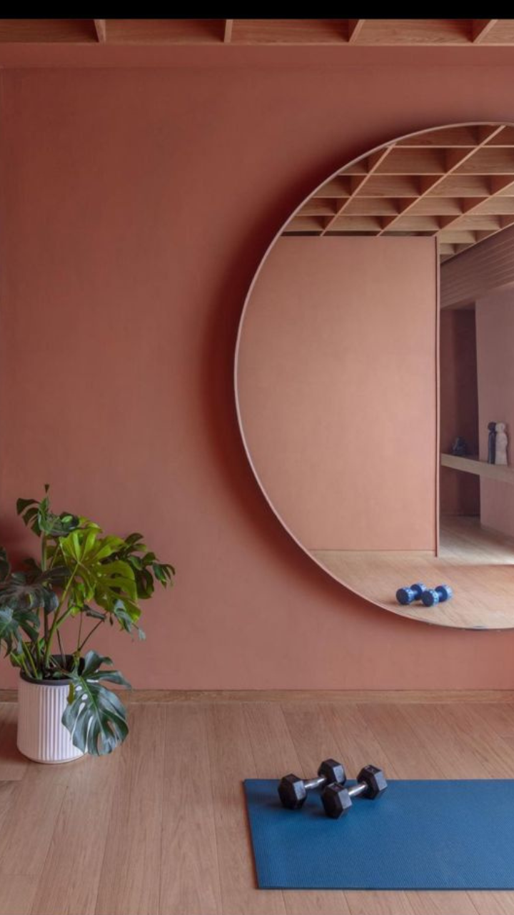 <p>The perfect space for a workout and then some cooling down is this room. With a beautiful mauve-pink room, a circle mirror, and a small monstera plant, this room gives a really chic aesthetic. </p>