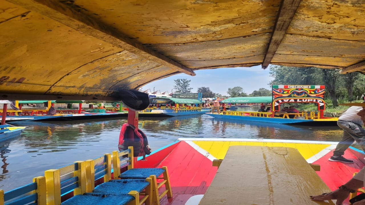 <p>Another must-do is a boat ride on a<span><em> tranjera</em> i</span>n the Xochilmilco area, about 35 minutes south of the city. <span>A <em>tranjera</em></span> is a brightly-colored flat-bottomed boat, similar to a gondola, which can transport up to 20 people. The canals were formerly used for transport for the Aztec capital of Tenochtitlan, built on a lake where Mexico City now sits on top of.  These boats are hired by the hour and come with a boat captain who controls the boats with a long wooden stick called a<span><em> remo. </em></span></p><p>There are 11 ports (<em>embarcaderos</em>) that offer these rides. While on the canals, you can purchase food, beer, or a mariachi song from other vendors. The boats are cash only — make sure to take pesos — and depending on which port you use, you may need to negotiate the price.</p><p>Pro Tip: It can be a bit confusing to choose between the various ports available, each offering different canal views and activities. Make sure to research specifically the one you want to head to for the best experience. While we went as a twosome, it also is probably the most entertaining as a group event, and you can share with strangers. </p>