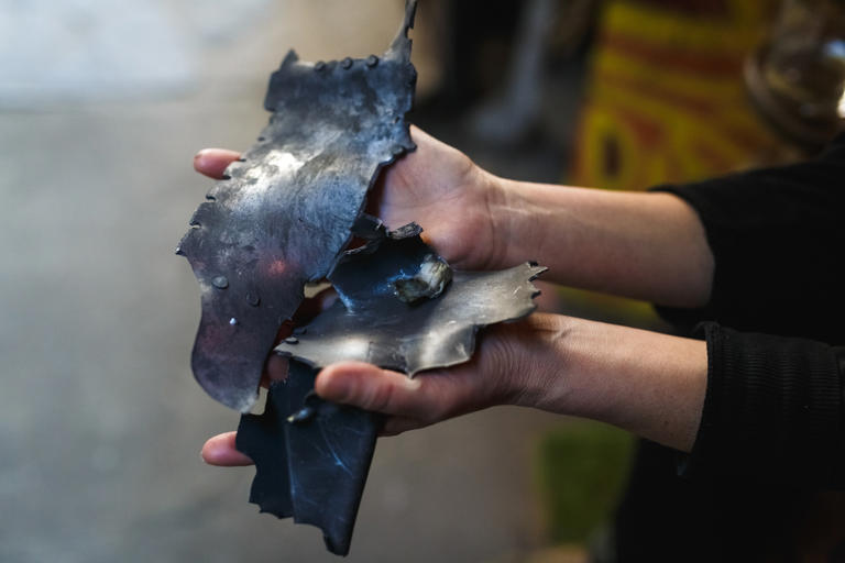 A person holds fragments of a Russian missile near an impact site on October 10, 2022 in Kyiv, Ukraine. Russia has modified its Kh-101 cruise missiles to accommodate two separate warheads, making them more lethal on the battlefield in Ukraine.