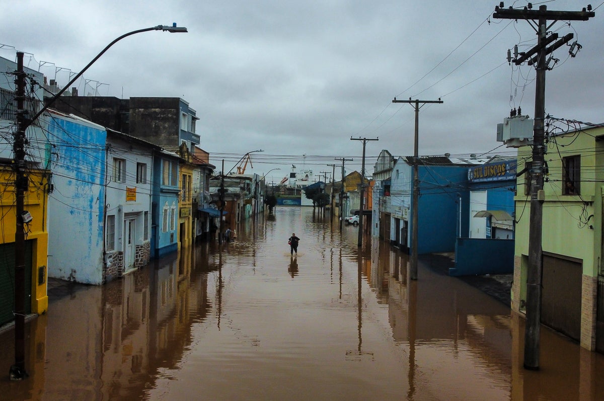 watch: brazilians navigate flooded streets by boat as at least 90 people confirmed dead