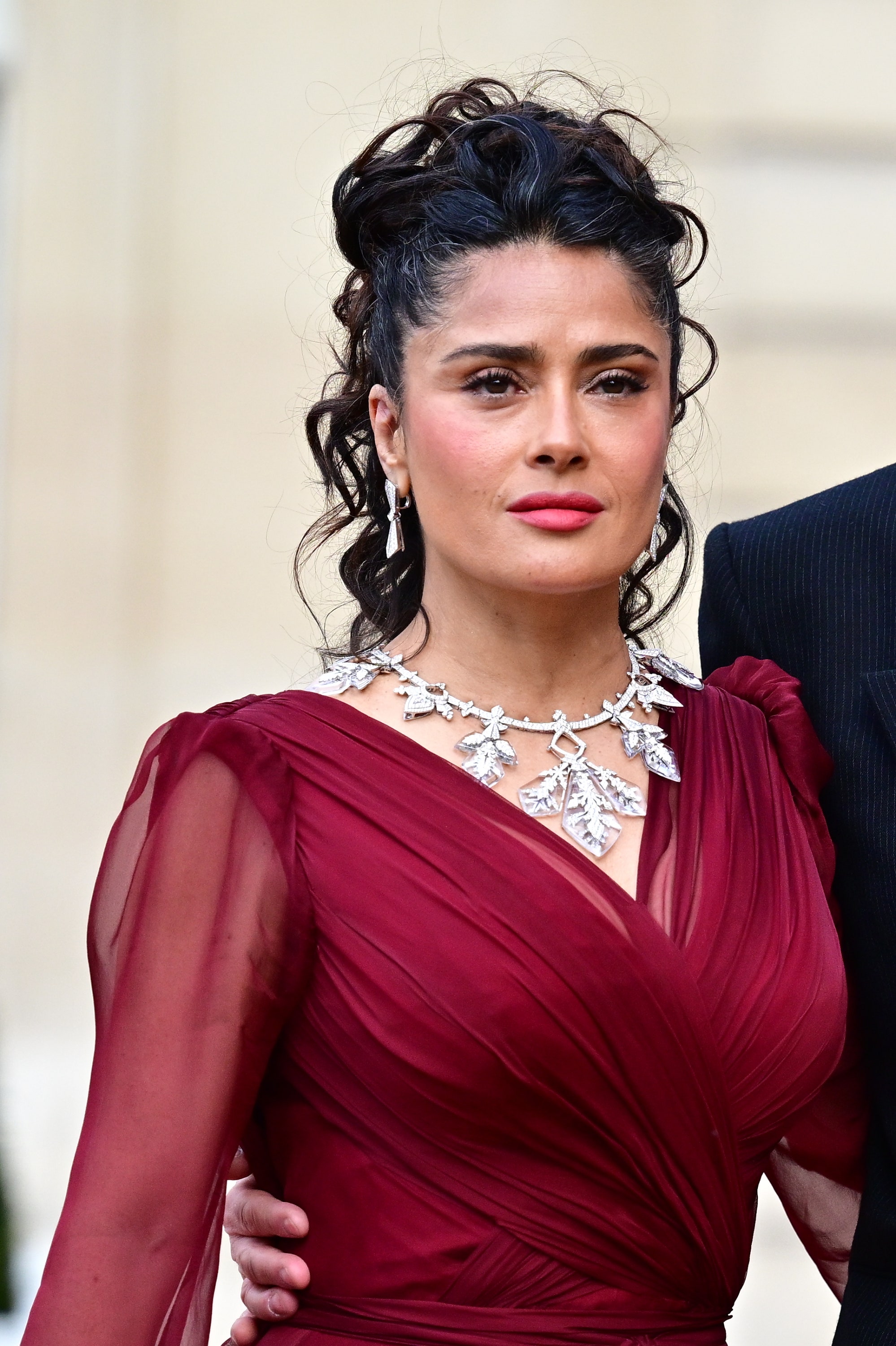 salma hayek demuestra que el vestido burdeos con accesorios plateados es la combinación más elegante