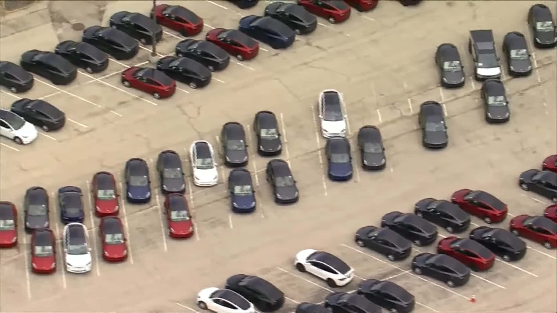 des centaines de tesla s’entassent dans un parking vacant d’un centre commercial