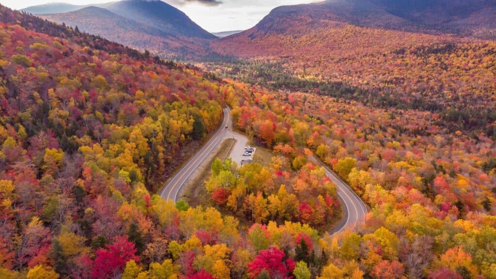 <p>New Hampshire’s 34.5-mile Kancamagus Highway is a sight for sore eyes during autumn. You’ll pass through dwindling roads with orange and yellow leaves lining gigantic trees, making it a once-in-a-lifetime experience. </p><p>From the  Rocky Gorge and Lower Falls waterfalls to the panoramic views from the Franconia Notch State Park to the delicious boozy beverages from the Tuckerman Brewing Company, this scenic byway is a great way to get some much-needed rest.</p>