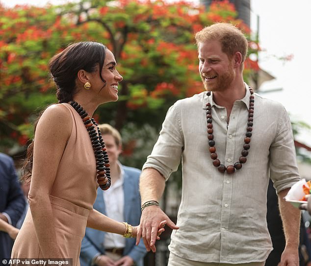 meghan sports backless dress as she joins harry in nigeria