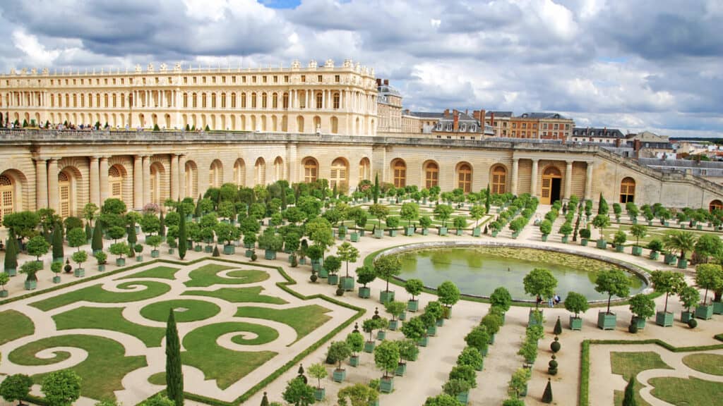 <p>What if you want to visit France and check out one of the most famous and beautiful palaces in Europe? The Palace of Versailles has been on UNESCO’s List of World Heritage Sites for over 30 years and is considered one of the most outstanding achievements of French art in the 18<sup>th</sup> century. </p><p>Located 12 miles southwest of the French capital, it was first Louis XIII’s lodge for hunting before the Sun King, Louis XIV, ultimately expanded and transformed it. He moved the French government and court to Versailles in 1682. All three French kings who resided there adjusted and improved the palace to increase its beauty and luxury. During the French Revolution, the chateau was dropped as an official seat of power. However, it still serves political functions. Heads of State are still regaled in the building’s Hall of Mirrors, and the politicians of modern France meet there for Congress.</p>