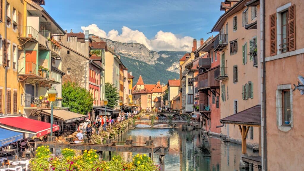 <p>Annecy is a picturesque town surrounded by mountains. Visitors can also explore the historic old town, with its winding canals, narrow streets, and colorful buildings. Its crystal-clear lake is a popular spot for boating and other activities. In addition, Annecy is known for its delicious local cuisine, including cheese and wine.</p>