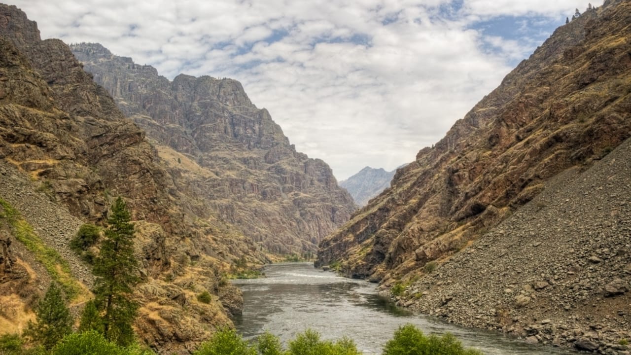 <p>Hells Canyon, on the border of Oregon and Idaho, is deeper than the Grand Canyon, with a maximum depth of 7,993 feet. This vast chasm is carved by the wild Snake River and is known for its dramatic elevation changes and rugged terrain. </p> <p>The canyon area is remote and largely inaccessible, making it a perfect spot for those looking to escape the crowds and explore nature.</p> <p>Visitors can enjoy whitewater rafting, fishing, and jet boat tours on the Snake River or hike along the many trails that offer panoramic views of the canyon’s dramatic depth and the surrounding mountains.</p>