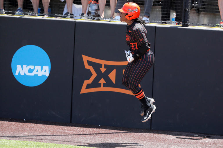 Oklahoma State utility Jilyen Poullard (27) celebrates after scoring a run in the first inning a softball game between the Oklahoma State Cowgirls and Michigan in the finals of the Stillwater Regional of the NCAA Tournament, Sunday, May 19, 2024. Oklahoma State won 4-1.