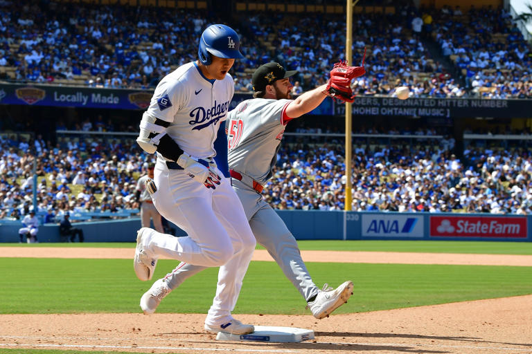 May 19, 2024; Los Angeles, California, USA; Los Angeles Dodgers designated hitter Shohei Ohtani (17) reaches first ahead of Cincinnati Reds pitcher Sam Moll (50) during the eighth inning at Dodger Stadium.