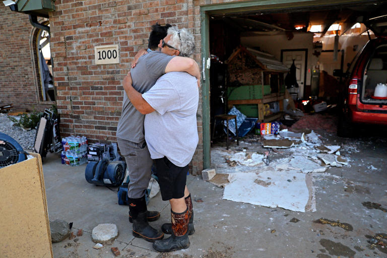 Homeowner Ray Gatto, right, hugs his son, Jordy Gatto, on Monday in front Ray's home in Oklahoma City. Gatto's home was damaged by a possible tornado came through the area near Cimarron Road and NW 10 on Sunday evening.