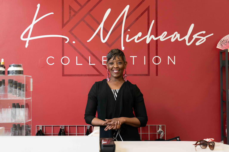 Patrice Newton, owner of K Michael's Collection, stands behind the register at her new boutique she opened in early May at West Ridge Mall.