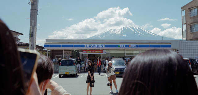 au japon, la vue imprenable sur le mont fuji devant une supérette masquée par un filet à cause du surtourisme