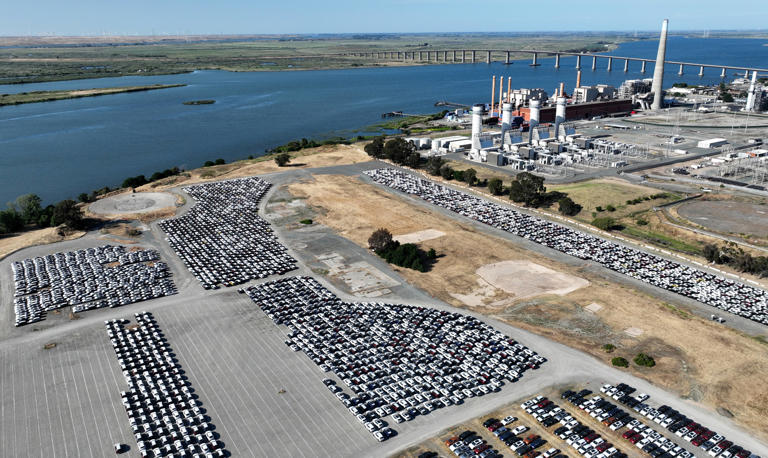 Newly shipped cars on the AMPORTS' lot on Wilbur Avenue in Antioch, Calif., on Monday, May 20, 2024. AMPORTS is an automotive logistics and processing facility where cars are shipped from abroad for distribution. The Gen On energy plant is to the right.