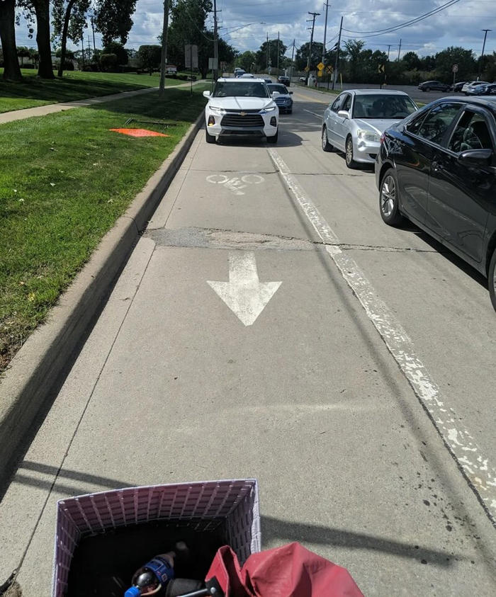 cyclist shares frustrating photo of car encroaching dangerously on bike lane: 'protected lanes should be used everywhere'