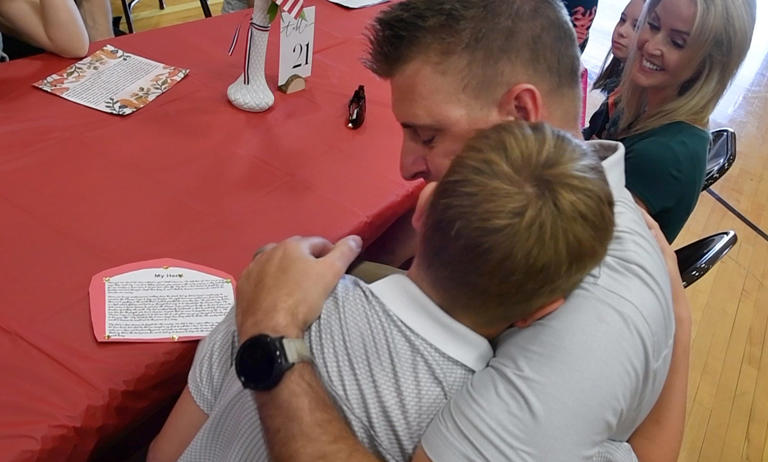 Andrew Wise, right, gives his son Brody a hug after he was named his hero during the program at Dover Area Middle School.
