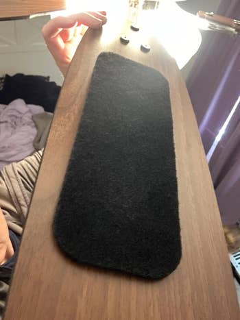 The black carbon filter attached to the blade of a reviewer's ceiling fan