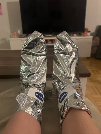 Feet propped up with two metallic foot masks on them