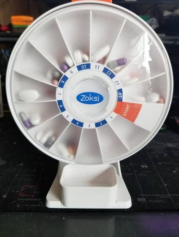 rotating Daily pill organizer with compartments labeled by day of the week,