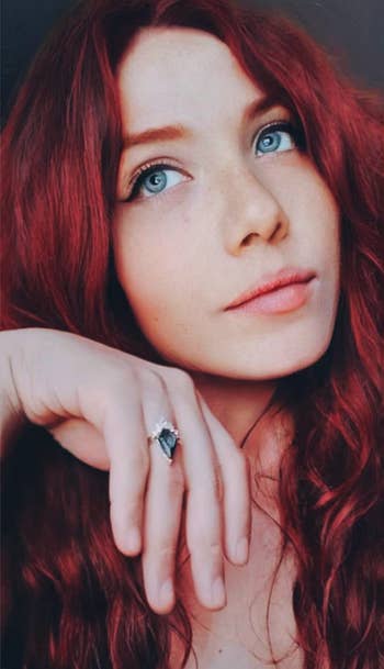 Reviewer wearing a diamond shaped blue cocktail ring with a gold setting