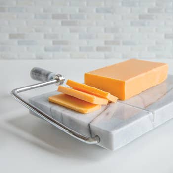 Sliced cheddar cheese resting on top of the board