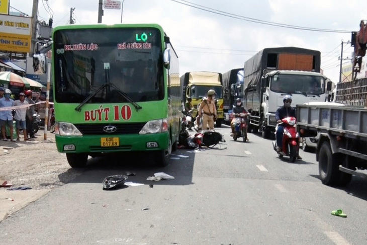 Xe tải húc xe máy văng vào xe buýt đang đậu ở lề đường đón trả khách, người đàn ông đi xe máy chết tại chỗ - Ảnh: MINH ĐĂNG