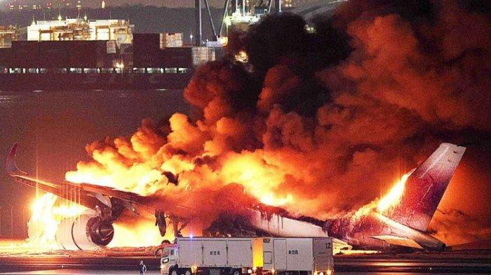 Foto yang disediakan oleh Jiji Press ini menunjukkan sebuah pesawat Japan Airlines terbakar di landasan pacu Bandara Haneda Tokyo pada Selasa (2/1/2024). Pesawat itu terbakar setelah tampaknya bertabrakan dengan pesawat penjaga pantai Jepang (JIJI PRESS/AFP/Japan OUT)