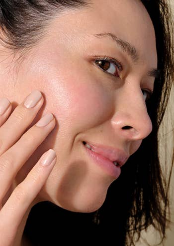 model blending sunscreen into cheek