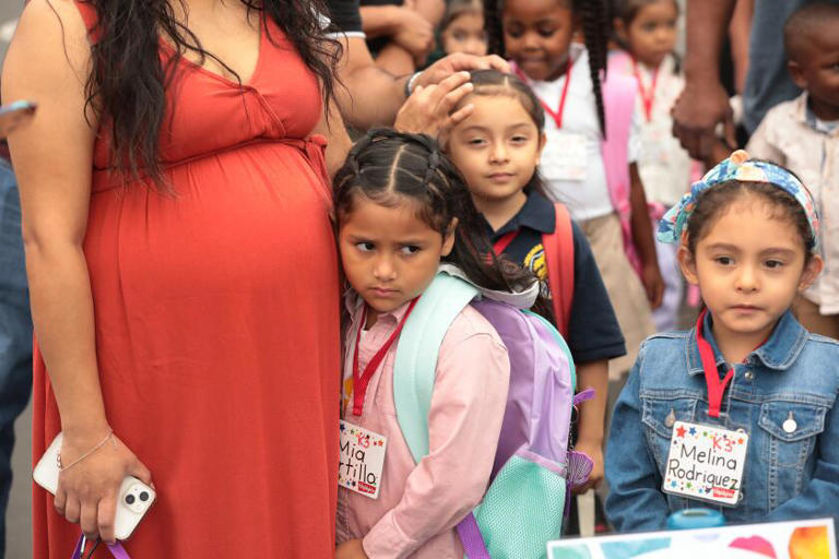 Transitional kindergarten student Melina Rodriguez, right, is ready as her friend Mia Portillo is comforted by her mother Daisy Salazar, left, as students assemble for the first day of school at Lenicia B. Weemes Elementary School. ((Al Seib / For The Times))