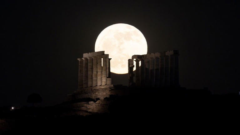 May's full moon shines over the Temple of Poseidon on Cape Sounion in Athens, Greece.