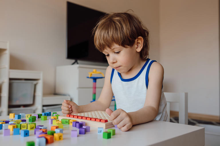 Photo of a young boy with autism playing with number blocks. Scientists are slowing unpicking the biochemical mechanisms behind autism spectrum disorders.