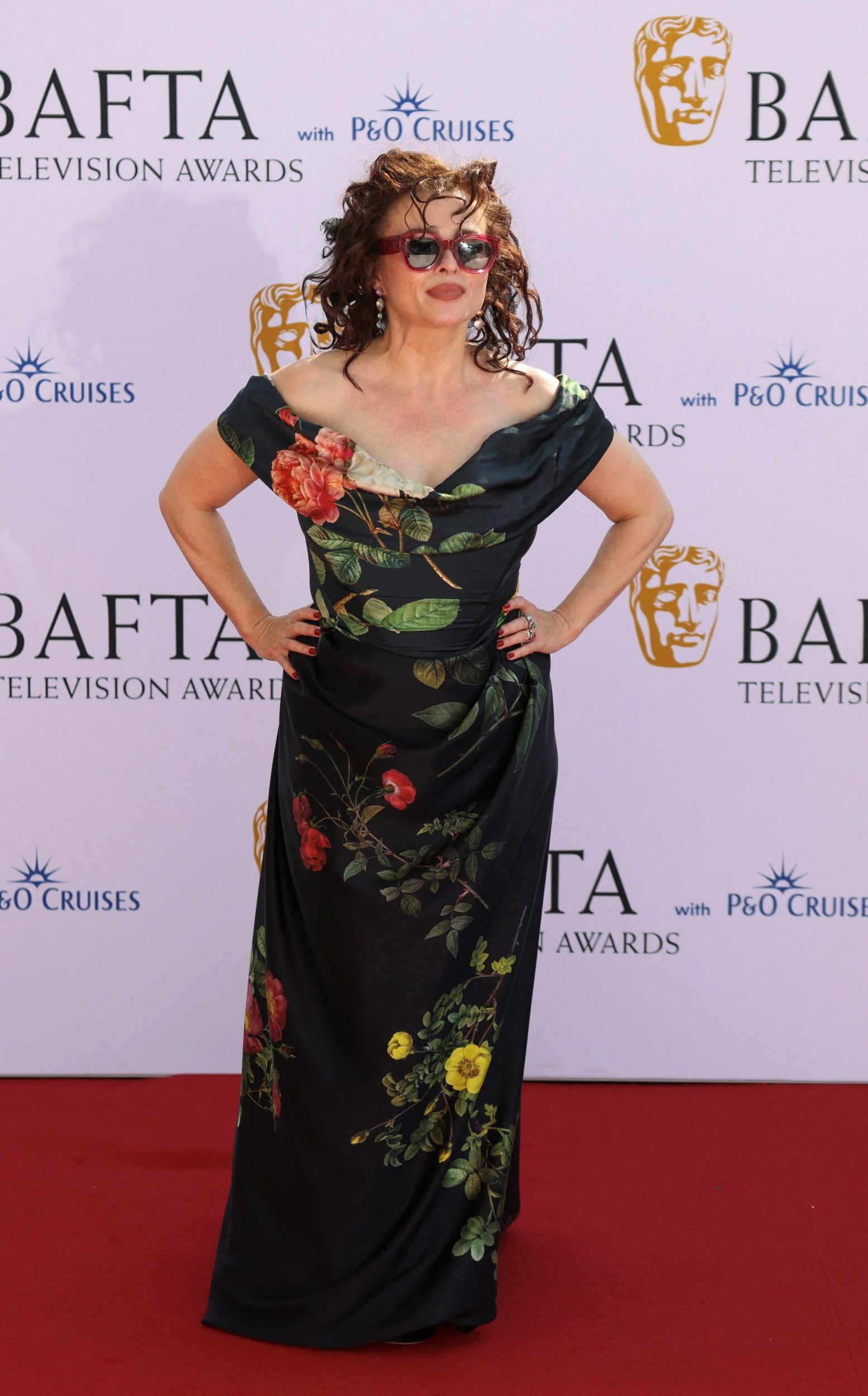 <p>Trust Helena Bonham Carter to rock a heatwave look; she paired her painterly dark floral off-shoulder gown with a pair of red sunglasses. </p>