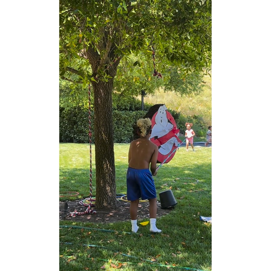 <p>Meanwhile, outside, Saint tried his hand at knocking down a <em>Ghostbusters</em> piñata that hung from a tree. After one swing, he took off his shirt to flex his muscles at the encouragement of guests.</p>