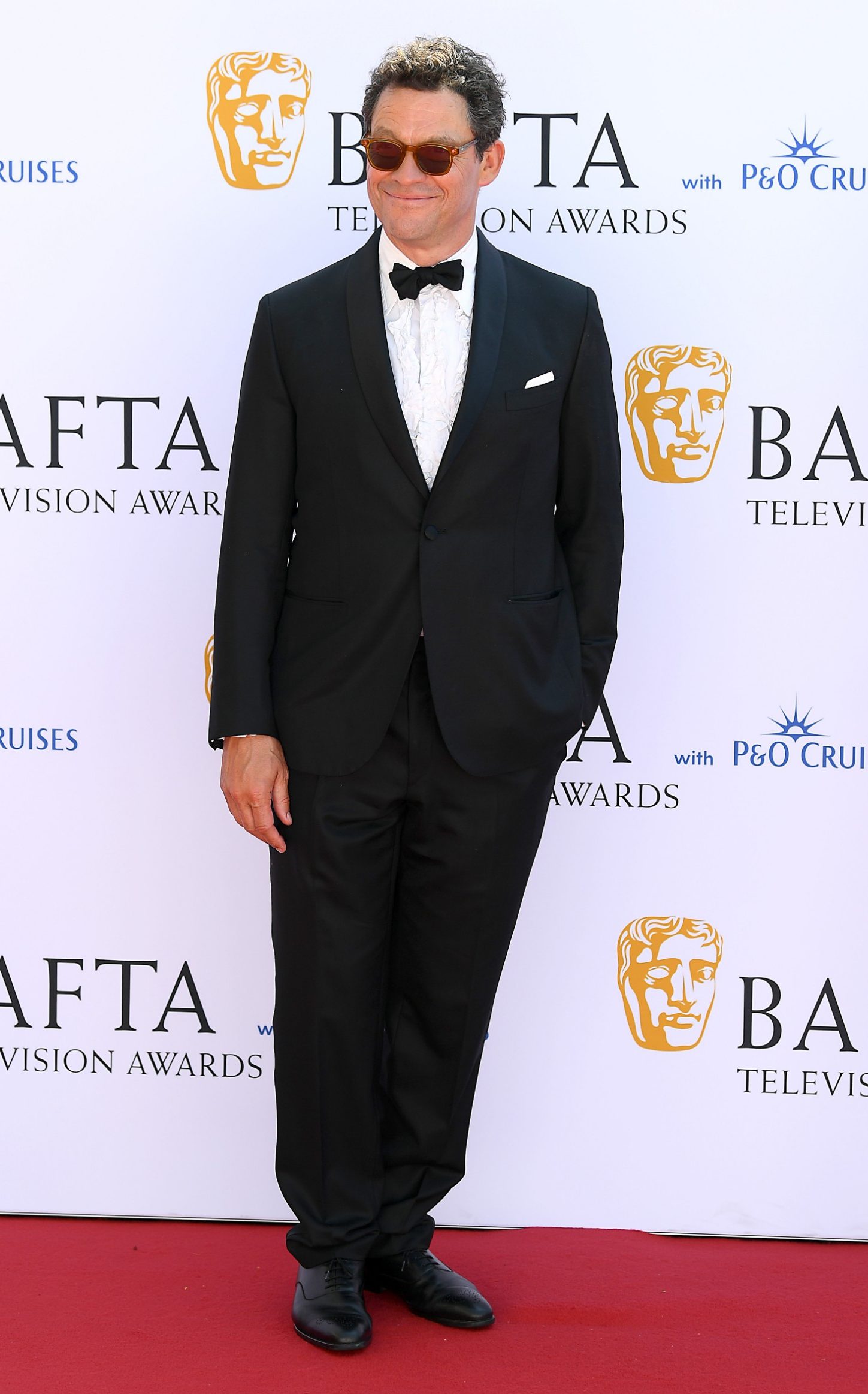 <p>Dominic West gave his classic black tie ensemble a laidback twist by styling it with a pair of sunglasses</p>