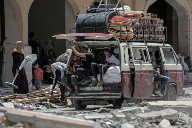 Des Palestiniens qui ont fui Rafah, dans le sud de la bande de Gaza, déchargent leurs affaires de l'arrière d'un camion à leur arrivée pour se réfugier à Khan Yunis le 12 mai 2024, au milieu du conflit en cours entre Israël et le groupe militant du Hamas.