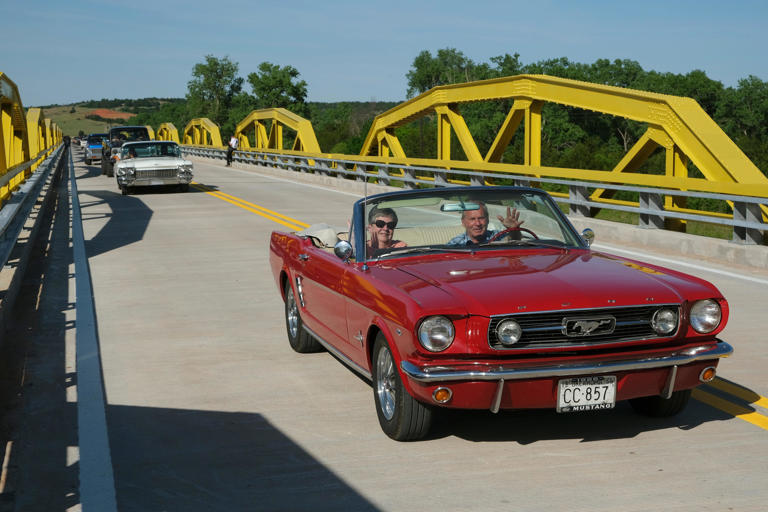 A couple in a convertible Ford Mustang take part in the parade across William H. Murray Bridge, or "Pony Bridge" after it officially opened Friday, May 10, 2024. The bridge in Oklahoma is the longest used for Route 66.