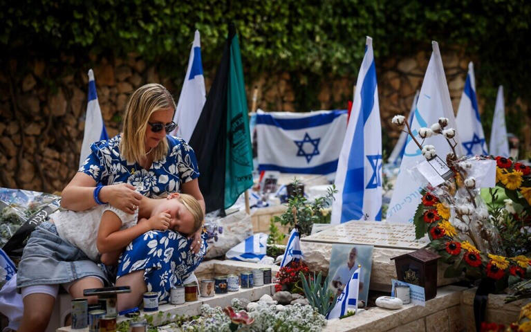 Hadas Hershkovitz, the widow of Israeli soldier Yossi Hershkovitz who was killed fighting in the Gaza Strip visits his grave on Israel's 76th Independence Day, at Mount Herzl Military Cemetery in Jerusalem on May 14, 2024. (Chaim Goldberg/Flash90)