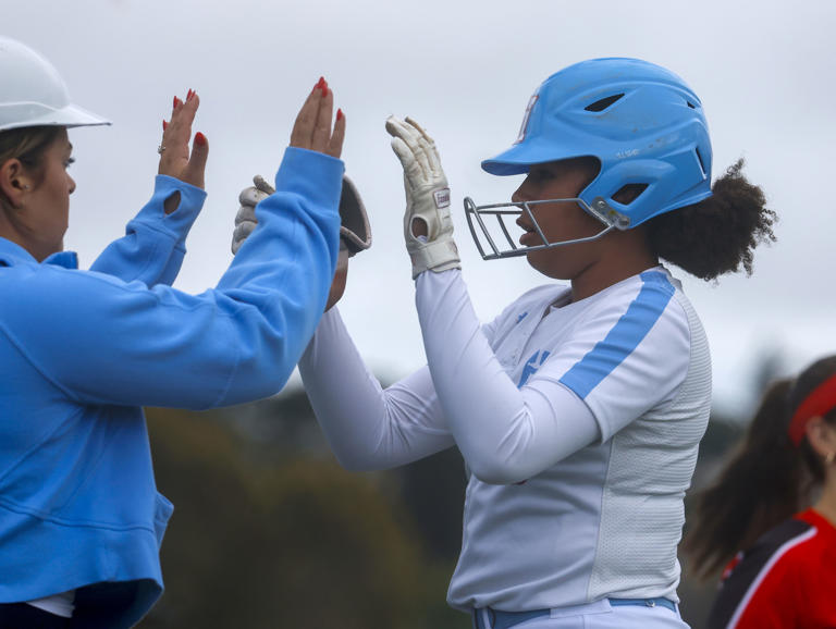Hillsdale's Lola Jones (17) gets a high-five after hitting an RBI single against Burlingame High School in the first inning at Hillsdale High School in San Mateo, Calif., on Thursday, April 25, 2024.