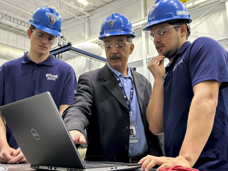 Habib Dagher, director of the advanced composites center, center, works with research assistants Ryan Thornton, left, and Mitchell Kelley, at the University of Maine, Wednesday, March 27, 2024, at the University of Maine, in Orono, Maine. (AP Photo/Robert F. Bukaty)